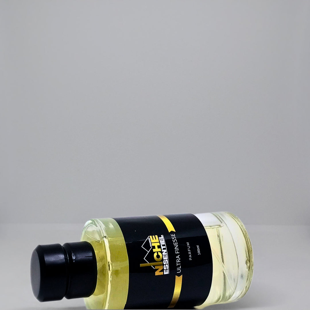 Transparent bottle of Niche Essentials Ultra Finess oil with a black cap and label.
