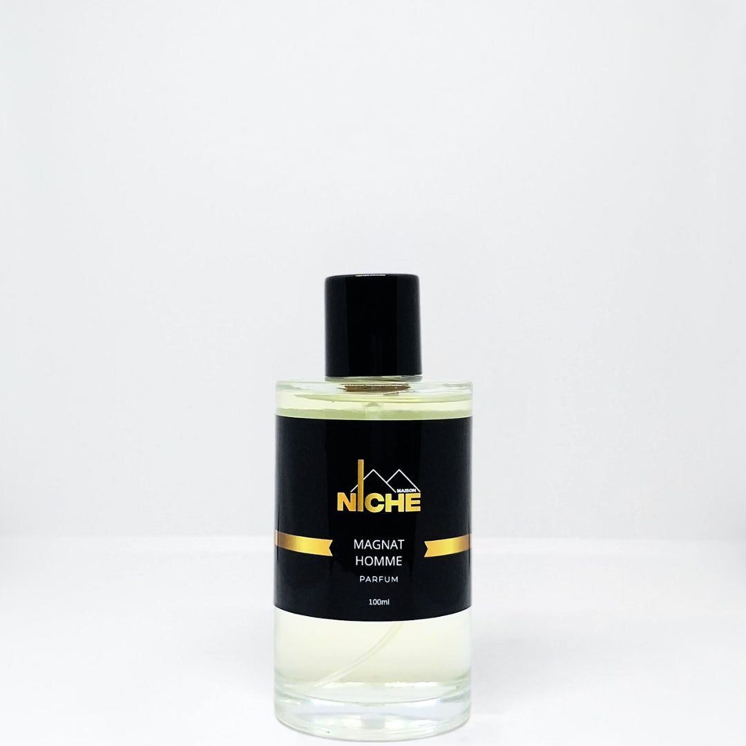 Clear glass bottle of Magnat Homme perfume with a black cap and label.