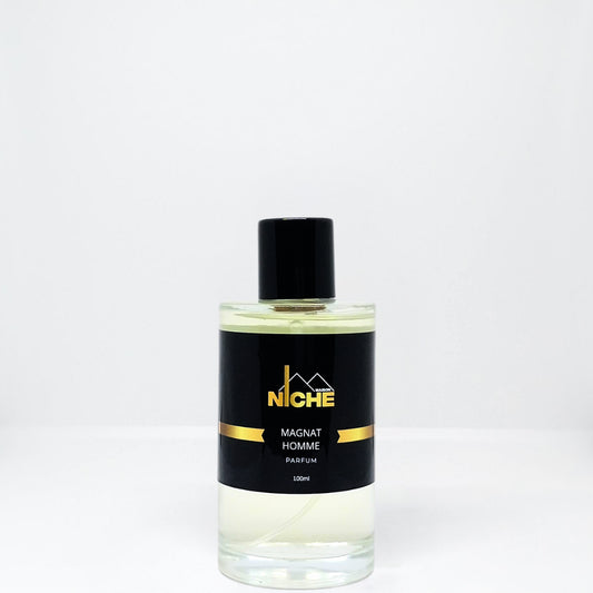 Clear glass bottle of Magnat Homme perfume with a black cap and label.