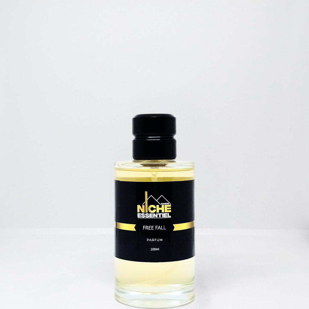 Clear glass bottle of Free Fall parfum with a black cap and label featuring the brand name Niche Essentiel.