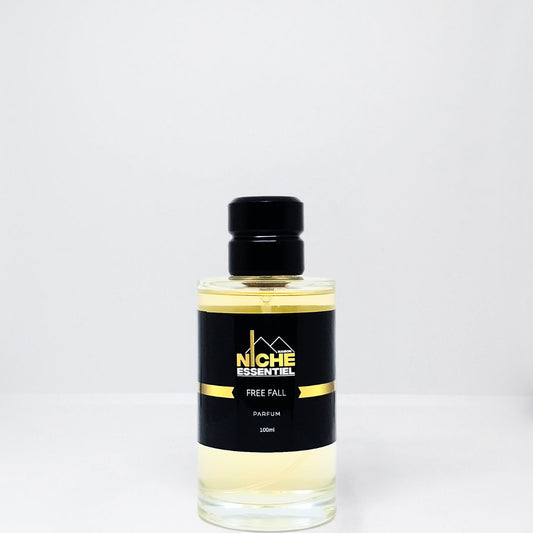 Clear glass bottle of Free Fall parfum with a black cap and label featuring the brand name Niche Essentiel.