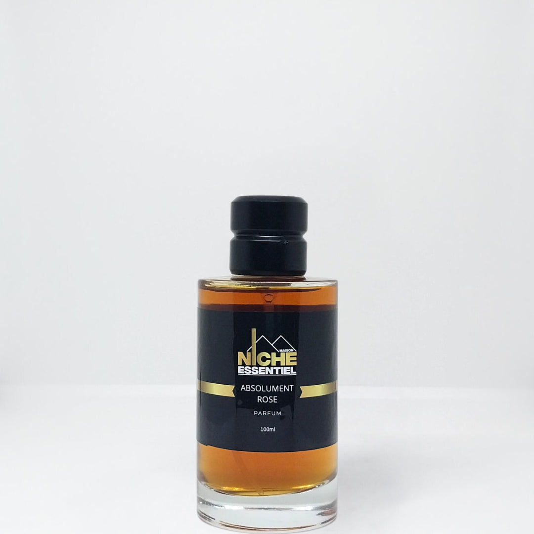 Glass bottle of Absolument Rose perfume with a black label and gold accents.