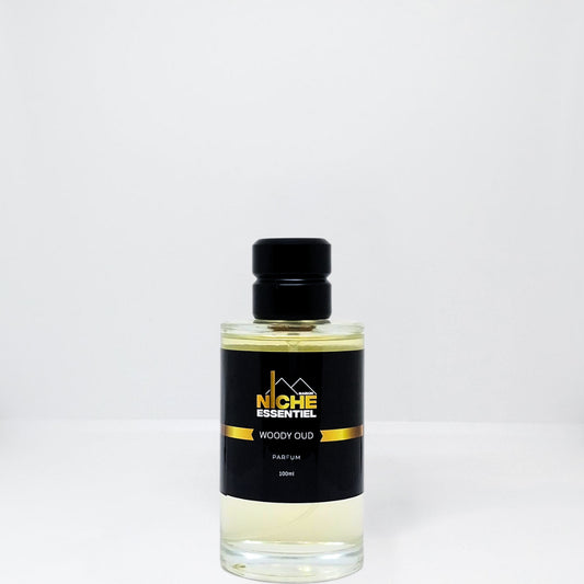 Bottle of Woody Oud perfume with a black cap and label featuring the brand name Niche Essentiel.