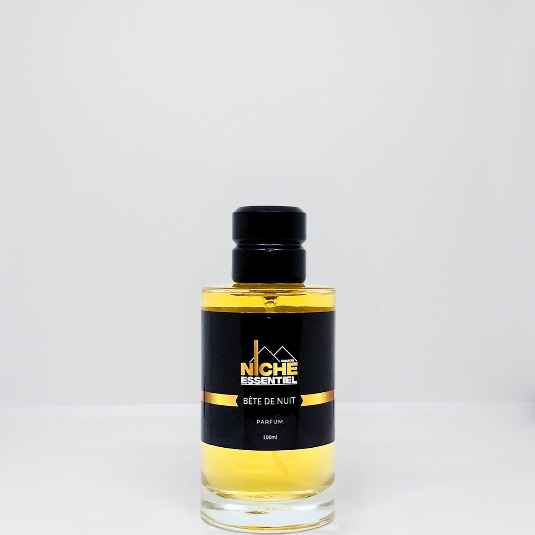 A glass bottle of Bête de Nuit perfume with a black label and gold accents.