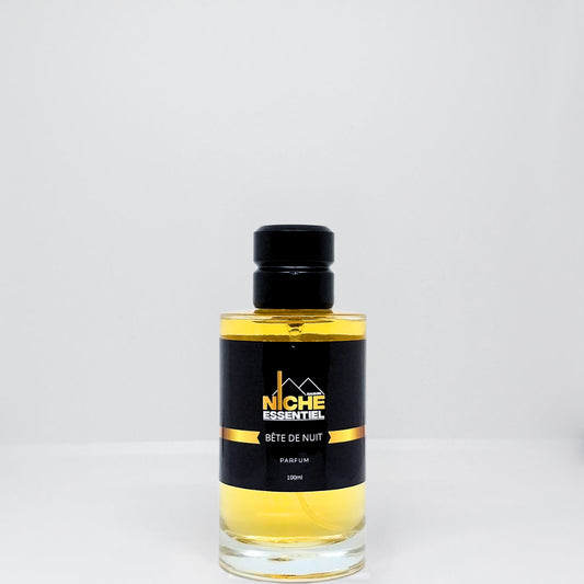 A glass bottle of Bête de Nuit perfume with a black label and gold accents.