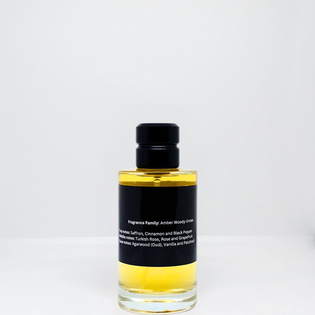 Clear glass bottle of amber woody unisex fragrance with a black label and black cap.
