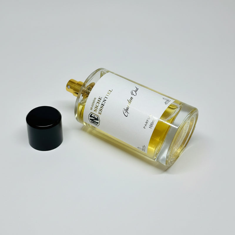 Bottle of Garden Oud perfume with a gold cap and detailed label showing fragrance notes.